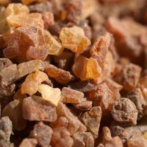 Close-up image of brown crystal-like rock fragments with translucent and opaque qualities, showcasing a variety of shades from amber to dark brown.