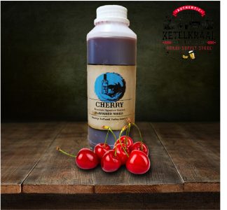 A bottle labeled "CHERRY Flavoured Vodka" on a wooden surface, with a group of fresh cherries in front of it. The background is dark with the logo "KETELKRAAL" at the top right corner.